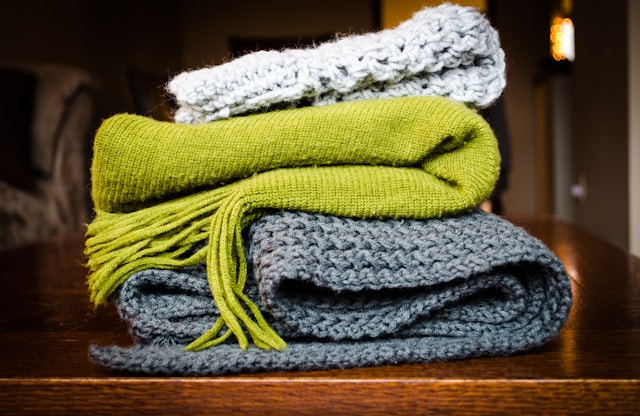 A bundle of 3 scarves, coloured white, green and grey.